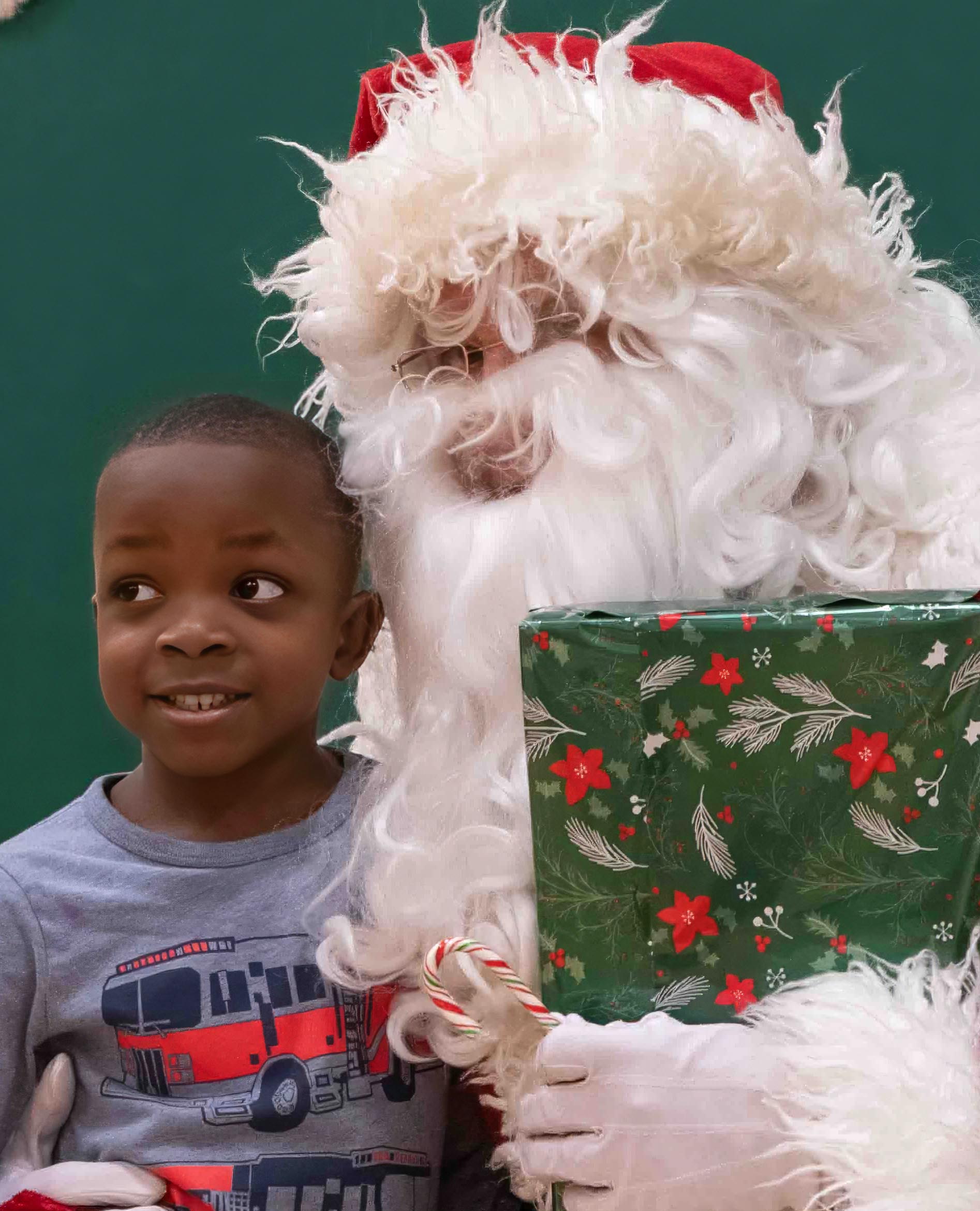 Jairius Mangondo receives a gift from Santa at the Yule Manor Co-op Christmas celebration held December 17 2023. Photo: Doug Banks