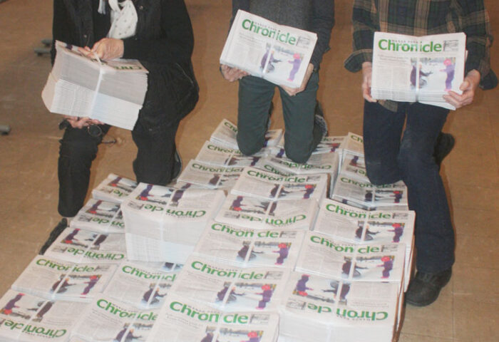 Chronicle distribution team members pose with raw bundles at the St. Columba church hall. Left to right are Circulation Manager Sharleen Tattersfield, bundling team members Celine Couture and Lynn Teeple. PHOTO: RYLAND COYNE
