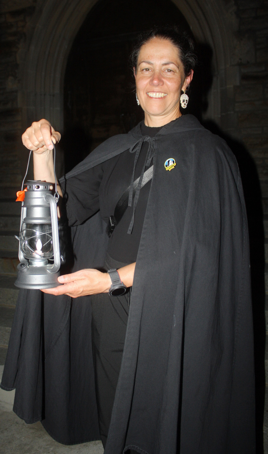 Haunted Walk guide Kathryn Lyons holds up a lantern to help guide visitors through the Beechwood Cemetery. PHOTO: Ryland Coyne